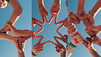 Blue sky, series and below of hands of friends outdoor for support, collaboration or teamwork. Group, low angle and men and women with star, fist bump and huddle for connection, solidarity or bonding