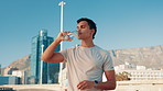 Drinking water, road and man in city for running marathon training, health and cardio fitness. Bottle, hydration and athlete in race with energy in street for sports exercise, workout and wellness