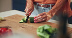 Kitchen counter, hands and cutting of cucumber, nutrition and healthy diet for lunch and meal prep. Home, nutritionist and person with process for salad, vegan and culinary skills with ingredients