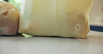 Groceries, recycling symbol and shopping bags on kitchen counter for eco friendly conservation. Ecology, reusable and sustainability with packets closeup in apartment for consumerism or zero waste