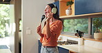 Dancing, headphones and woman singing in kitchen with spoon for music, fun or entertainment. Energy, karaoke and female person moving with audio tech for playlist, album or radio online in home.