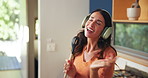 Singing, headphones and woman in kitchen with spoon for music, fun or entertainment with dance. Energy, karaoke and female person moving with audio tech for playlist, album or radio online in home.
