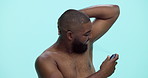Happy man, deodorant and spray with bottle in studio for cologne or perfume on a blue background. Portrait, male person or model with arm pit for fresh smell, body odor or fragrance on mockup space