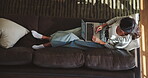 Laptop, relax and woman on sofa in living room of home from above for holiday or vacation booking. Break, computer and morning with person on couch in apartment to search for hotel accommodation