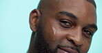Serum, glow and face with black man in studio for skincare cosmetics, dermatology and self care. Clean, beauty and oil with person and dropper on blue background for hydration, vitamin c and shine