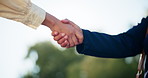 Business people, handshake or meeting at park for partnership, agreement or deal together. Closeup, employee or colleagues shaking hands with b2b for collaboration, teamwork or introduction in nature
