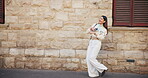 Business, woman and dance with earphones in city for listening to music, streaming audio and travel fun. Person, rhythm and movement with energy for playlist, morning commute and freedom for journey