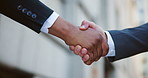 Handshake, deal and business men in city for investment agreement, partnership or meeting. Welcome, greeting and finance banker shaking hands with investor for contract, thank you or greeting in town