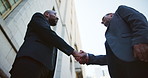 Handshake, introduction and business men in city for investment, partnership or meeting. Welcome, agreement and banker shaking hands with investor for contract, thank you or greeting from below.