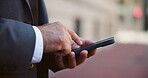Business, hands and man with phone in city for online travel booking, check ride schedule and typing location. Closeup, professional and smartphone on sidewalk for road directions and map navigation