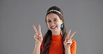 Face, peace sign and smile with woman in studio for emoji, social media or profile picture. Energy, funny and silly with happy or playful influencer on gray background for expression or hand gesture