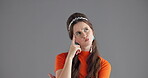 Confused, woman and thinking with doubt in studio for ideas, planning and choice for solution. Shocked, female person and point of thoughts, decision and answer for problem solving on gray background