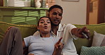 Pointing, relax and watching tv with couple on sofa in living room of home for streaming service. Comedy, laughing and television with people in apartment together for entertainment or subscription