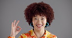 Happy woman, face and okay with afro in studio for fashion or style on a gray background. Portrait, female person or model with smile, emoji or ok sign for perfection, excellent or accuracy on space