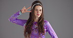 Face, dancing and happy woman in studio, peace sign and confident personality on gray background. Portrait, person and dancer with smile, model or trendy clothes with stylish outfit, fashion or retro