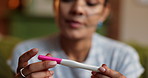 Hands, home and woman with positive pregnancy test, face and excited for maternity or motherhood. Good news, fertility and satisfied with results, pregnant person and stick for IVF success at house
