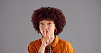 Happy woman, face and secret with afro in studio for confidential or rumor on a gray background. Portrait, female person or smile with finger on lips for gossip, private or hush on mockup space