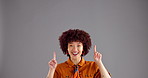 Happy woman, face and pointing up with space in studio for advertising or marketing on a gray background. Portrait, female person or model with smile, selection or choice for notification or options