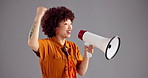 Happy woman, announcement or deal with loudspeaker for promotion or motivation on a gray background. Female person, model or smile with bullhorn in joy for cheering, alert or winning on mockup space