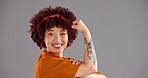 Happy, muscle and face of woman in studio for empowerment, strength and confidence. Space, champion and portrait of person with strong arm flex for power, pride and success on gray background