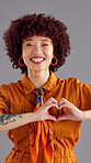 Happy, heart hand and face of woman in studio with positivity, comfort or gratitude. Smile, portrait and female person from Brazil with love emoji for support, care or kindness by gray background.