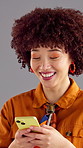 Happy woman, typing and browsing with phone in studio for social media on a gray background. Female person, model or user with smile or afro on mobile smartphone for online chatting or texting app