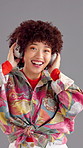 Sound, headphones and happy woman dance in studio with energy for favorite song on gray background. African person, excited and listen to audio, streaming music or hip hop playlist on radio with tech