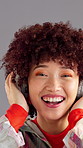 Audio, headphones and happy woman dance in studio with energy for favorite song on gray background. African person, face and listening to music, streaming sound or hip hop playlist on radio with tech