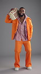Dancer, radio and fashion with face of black man in studio for retro style, funky vibe and bohemian culture. Groovy streaming, indie aesthetic and disco music with person on gray background for sound