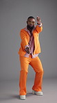 Glasses, dancing and black man with fashion, retro clothes and energy on gray background. African person, model and vintage outfit with shades, stylish wardrobe and smile with happiness and colourful