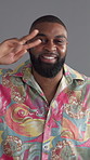 Face, dancing and black man with fashion, vintage clothes and confident personalty on gray background. African person, model and retro outfit with peace sign, stylish wardrobe and smile with culture