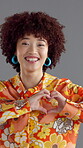 Woman, face and fashion in studio with heart hands, happy or love emoji with confidence. Girl, retro style or laugh on gray background with reaction, like icon or gesture for Valentines day in Brazil