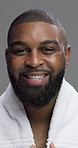 Face, skincare and black man with smile, towel and dermatology on gray studio background. African person, portrait and model with cosmetics, grooming and healthy skin with treatment, shine and laugh
