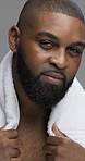 Face, skincare and black man in studio, towel and dermatology on gray background. African person, portrait and model with cosmetics, grooming routine and healthy skin with treatment and confidence