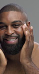Face, moisturizing and man with smile, skincare and self care with facial treatment, shine or studio. Gray background, happy and black person with routine for glow, dermatology or grooming in morning