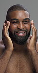 Studio, beauty and man with routine for skincare, moisturizing and facial treatment for glow in morning. Gray background, happy and black person with cosmetics, confident and dermatology for face