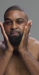 Studio, moisturizing and man with beard, face and oil to prevent dry skin in morning or cosmetics. Gray background, grooming and black person with serum for skincare, routine or self care with liquid