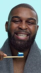 Black man, face and toothbrush for brushing teeth, smile and bamboo on blue background. Dental health, oral care and fresh breath with male person in studio, towel and routine with toothpaste