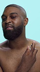 Face, spray and black man in studio, scent and smile with confidence on blue background. African person, perfume or happy model with fragrance, cologne and self care with body fresh, smell or hygiene