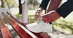 Tying, shoelace and  preparation for exercise, legs and athlete with footwear for fitness and outdoor. Park, feet and person with sneakers for workout, sports and sportswear for routine in morning