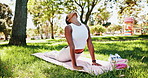 Fitness, woman and park with yoga for exercise, workout or holistic stretching on outdoor grass. Active, female person or yogi with cobra pose or zen for wellness, health or mindfulness in nature