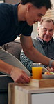 Caregiver, senior man and breakfast in home, reading and relax on sofa with book, food and kindness. Male nurse, elderly patient and smile for meal with help, service and literature in retirement