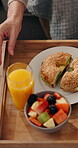 Food, hands and breakfast tray in home for morning meal, bagel sandwich and healthy nutrition. Above, senior person and fresh lunch with juice, fruit and organic diet for wellness, brunch and hungry
