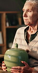 Ashes, sadness and thinking with senior woman in retirement home for loss or nostalgia. Depression, grief or memories and unhappy old person with jar in apartment for loneliness, mistake or regret