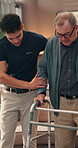 Caregiver, old man and walker with help in home, support or assistance for mobility, recovery or rehabilitation. Healthcare worker, senior patient and guide for walking, balance and elderly care