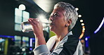 Mature, woman and drinking water in gym for health, wellness and hydration after workout. Thirsty, flare and bottle with h2o for nutrition, minerals and electrolytes for exercise at fitness center