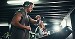 Man, headphones and treadmill with watch in gym for fitness, endurance and sweat with music. Training, check progress time or serious runner with machine, people and cardio exercise for podcast