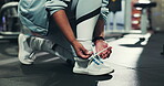 Hands, shoes and tying laces in gym for fitness, run or start exercise routine for health or wellness. Person, athlete and ready for workout, training or sports with sneakers for preparation at club