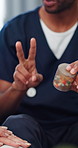 Hands, home and nurse with pills, explain and person with wellness, senior medication or help. Closeup, caregiver or elderly patient on sofa, tablets or prescription drugs with healthcare or recovery