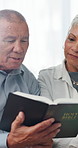House, elderly and Christian couple reading book for spiritual religion for peace, guidance and learning. Senior, retirement or people with literature, scripture or bible with prayer, faith or gospel